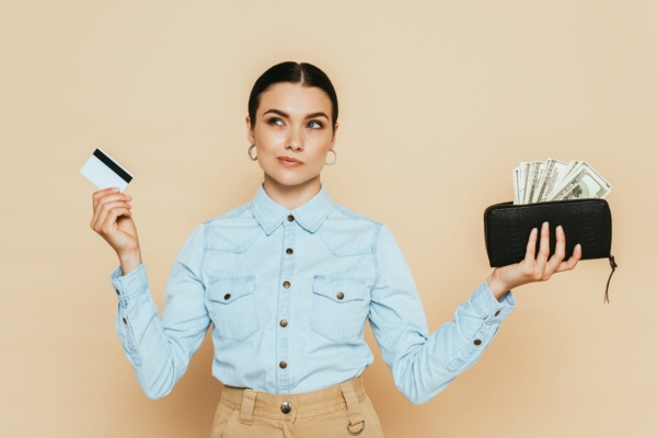 image of a thinking woman with card and cash on each hand depicting Price of Scheduled Propane Service