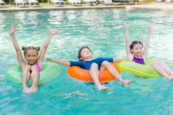 kids in floaters in the swimming pool