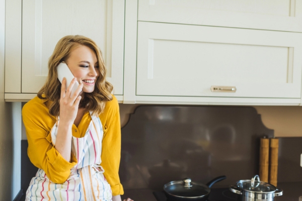 woman in the kitchen calling for oil delivery from home phone