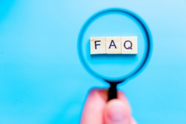 FAQ spelled using wooden letter chips highlighted by a magnifying glass depicting Home Heating Oil Efficiency