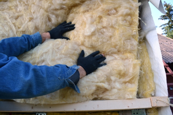 man's hand on insulation material for the house