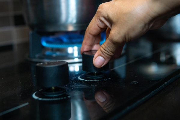 Close up view of hand adjusting the gas stove knob
